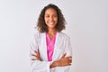 Young brazilian doctor woman wearing coat standing over isolated white background happy face smiling with crossed arms looking at Royalty Free Stock Photo