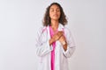 Young brazilian doctor woman wearing stethoscope standing over isolated white background smiling with hands on chest with closed Royalty Free Stock Photo