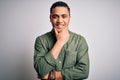 Young brazilian man wearing casual shirt standing over isolated white background looking confident at the camera smiling with Royalty Free Stock Photo