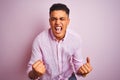 Young brazilian man wearing shirt standing over isolated pink background very happy and excited doing winner gesture with arms Royalty Free Stock Photo