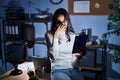 Young brazilian woman using touchpad at night working at the office tired rubbing nose and eyes feeling fatigue and headache Royalty Free Stock Photo