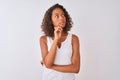 Young brazilian woman wearing casual t-shirt standing over isolated white background with hand on chin thinking about question, Royalty Free Stock Photo