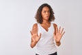 Young brazilian woman wearing casual t-shirt standing over isolated white background Moving away hands palms showing refusal and Royalty Free Stock Photo