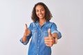 Young brazilian woman wearing denim shirt standing over isolated white background approving doing positive gesture with hand, Royalty Free Stock Photo