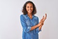 Young brazilian woman wearing denim shirt standing over isolated white background clapping and applauding happy and joyful, Royalty Free Stock Photo