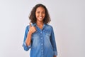 Young brazilian woman wearing denim shirt standing over isolated white background doing happy thumbs up gesture with hand Royalty Free Stock Photo