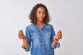 Young brazilian woman wearing denim shirt standing over isolated white background doing money gesture with hands, asking for Royalty Free Stock Photo