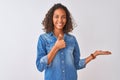 Young brazilian woman wearing denim shirt standing over isolated white background Showing palm hand and doing ok gesture with Royalty Free Stock Photo