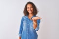 Young brazilian woman wearing denim shirt standing over isolated white background smiling cheerful offering palm hand giving Royalty Free Stock Photo