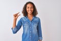 Young brazilian woman wearing denim shirt standing over isolated white background smiling and confident gesturing with hand doing Royalty Free Stock Photo