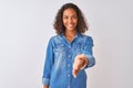 Young brazilian woman wearing denim shirt standing over isolated white background smiling friendly offering handshake as greeting Royalty Free Stock Photo
