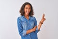 Young brazilian woman wearing denim shirt standing over isolated white background smiling with happy face winking at the camera Royalty Free Stock Photo