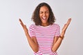 Young brazilian woman wearing pink striped t-shirt standing over isolated white background celebrating mad and crazy for success Royalty Free Stock Photo