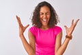 Young brazilian woman wearing pink t-shirt standing over isolated white background celebrating mad and crazy for success with arms Royalty Free Stock Photo