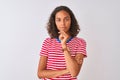 Young brazilian woman wearing red striped t-shirt standing over isolated white background looking confident at the camera smiling Royalty Free Stock Photo