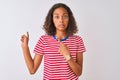 Young brazilian woman wearing red striped t-shirt standing over isolated white background Pointing aside worried and nervous with