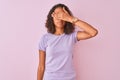 Young brazilian woman wearing t-shirt standing over isolated pink background covering eyes with hand, looking serious and sad Royalty Free Stock Photo