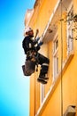 Young bricklayer climber doing repair work in a facade of Lisbon