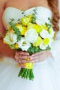 Young bride in a beautiful dress holding a bouquet in hands