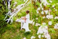 Young bride with blond hair in white negligee and stockings putting on a garter