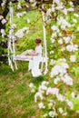 Young bride with blond hair in white negligee and stockings putting on a garter