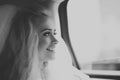 Young bride in a car looking in a window