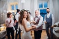 A young bride dancing with grandfather and other guests on a wedding reception. Royalty Free Stock Photo