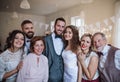 A young bride, groom and guests posing for a photograph on a wedding reception. Royalty Free Stock Photo