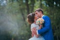 Young bride and groom kissing on the background of the forest Royalty Free Stock Photo