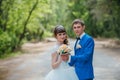 Young bride and groom kissing on the background of the forest the road Royalty Free Stock Photo