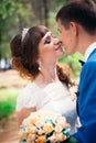 Young bride and groom kissing on the background of the forest the road Royalty Free Stock Photo