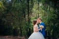 Young bride and groom kissing on the background of the forest the road Royalty Free Stock Photo