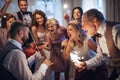 A young bride, groom and other guests dancing and singing on a wedding reception. Royalty Free Stock Photo