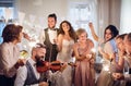 A young bride, groom and other guests dancing and singing on a wedding reception. Royalty Free Stock Photo
