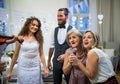 A young bride and groom with other guests dancing and singing on a wedding reception. Royalty Free Stock Photo