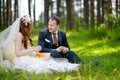 Young bride and groom sitting on a grass Royalty Free Stock Photo