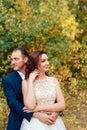 Young bride and groom walking in autumn Park with yellow leaves Royalty Free Stock Photo