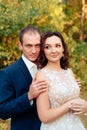 Young bride and groom walking in autumn Park with yellow leaves Royalty Free Stock Photo