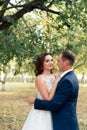 Young bride and groom walking in a summer Park with green trees Royalty Free Stock Photo