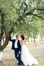 Young bride and groom walking in a summer Park with green trees Royalty Free Stock Photo