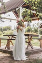 young bride hiding face with bouquet of