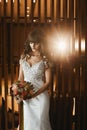 Young bride in luxurious wedding dress posing at the interior. Young model woman with bright bridal makeup in a bridal Royalty Free Stock Photo