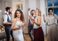 A young bride with other guests dancing on a wedding reception.