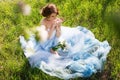 Young bride sitting on the grass in the park Royalty Free Stock Photo