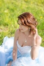 Young bride sitting on the grass in the park Royalty Free Stock Photo