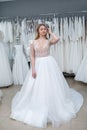 The young bride tries on an elegant wedding dress and pose in the salon Royalty Free Stock Photo