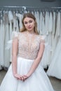 The young bride tries on an elegant wedding dress and pose in the salon Royalty Free Stock Photo