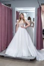 The young bride tries on an elegant wedding dress and pose in the salon Royalty Free Stock Photo