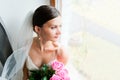 Young bride waits for groom near the window