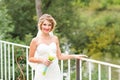 Young bride in wedding dress holding bouquet, outdoors Royalty Free Stock Photo